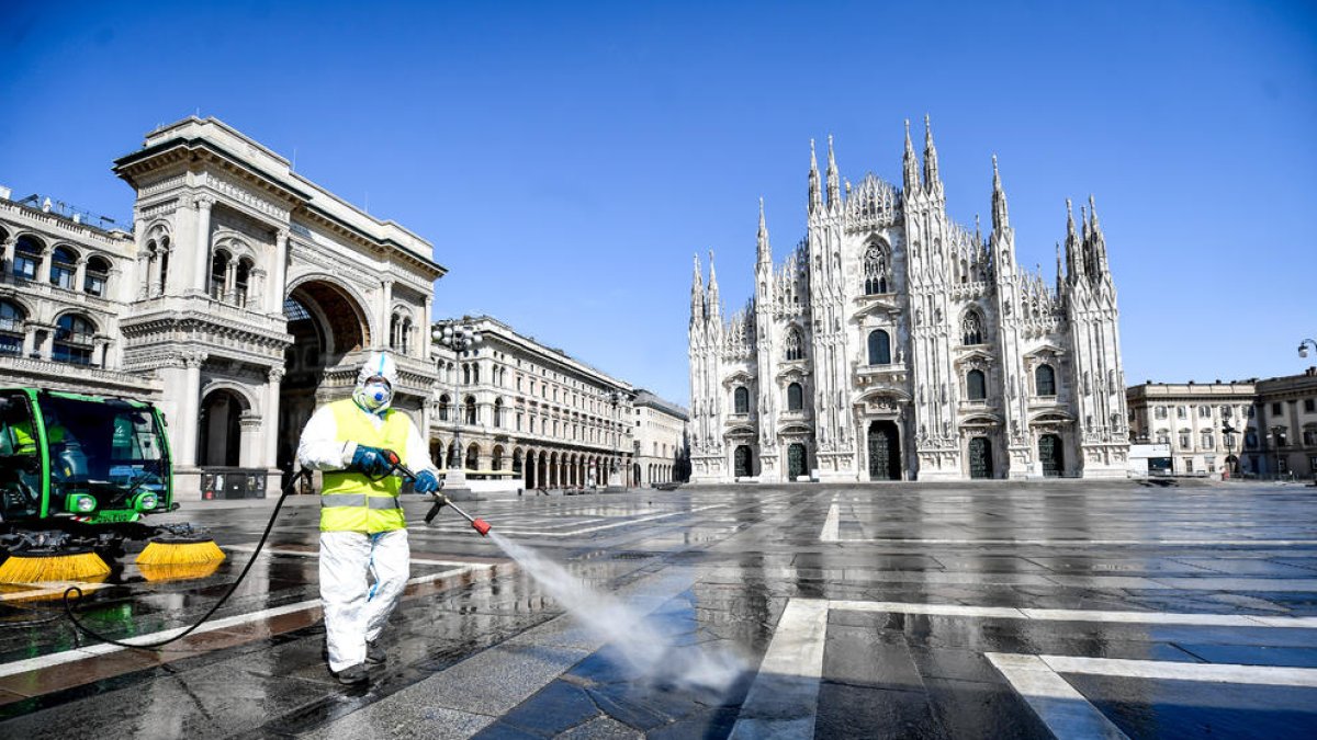 Un treballador italià efectua tasques de desinfecció del terra de la Piazza del Duomo de Milà.