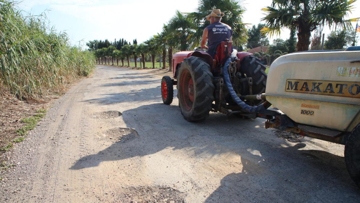 Un tractor en un camí ple de sots a Vallcalent.