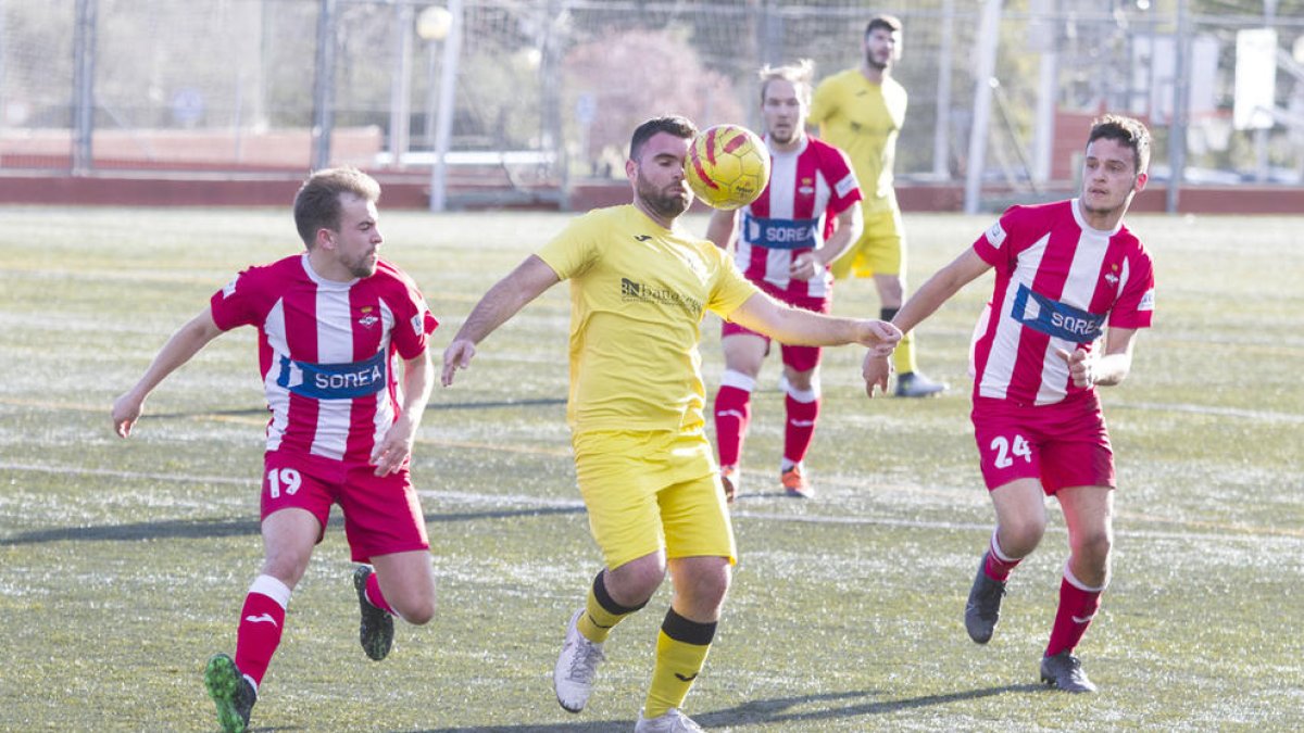 Ciru intenta mantener la posesión del balón ante la presión de dos jugadores del Valls.