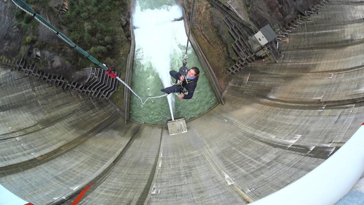 Los preparativos para saltar desde lo alto de la presa de la Llosa en esta modalidad llamada ‘bungee’ y un cliente tras efectuar el salto.