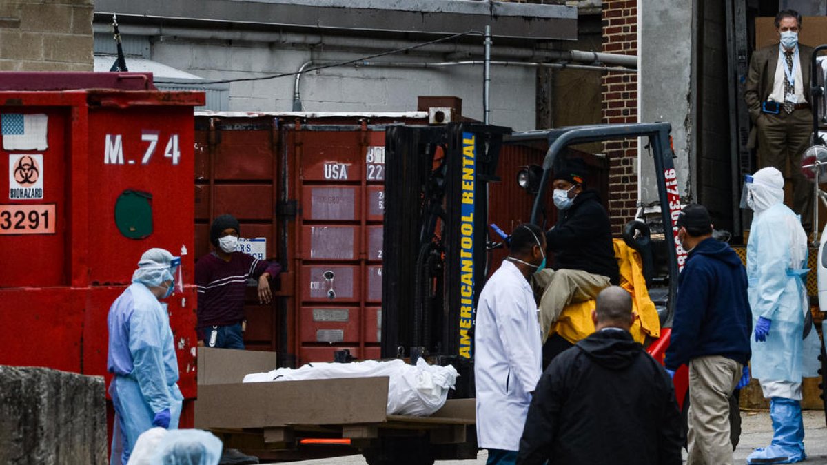Operarios trasladan cadáveres de víctimas del coronavirus a una morgue provisional en Nueva York.
