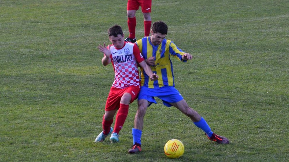 Un jugador del Sudanell prova de protegir la pilota davant d’un del Balaguer.
