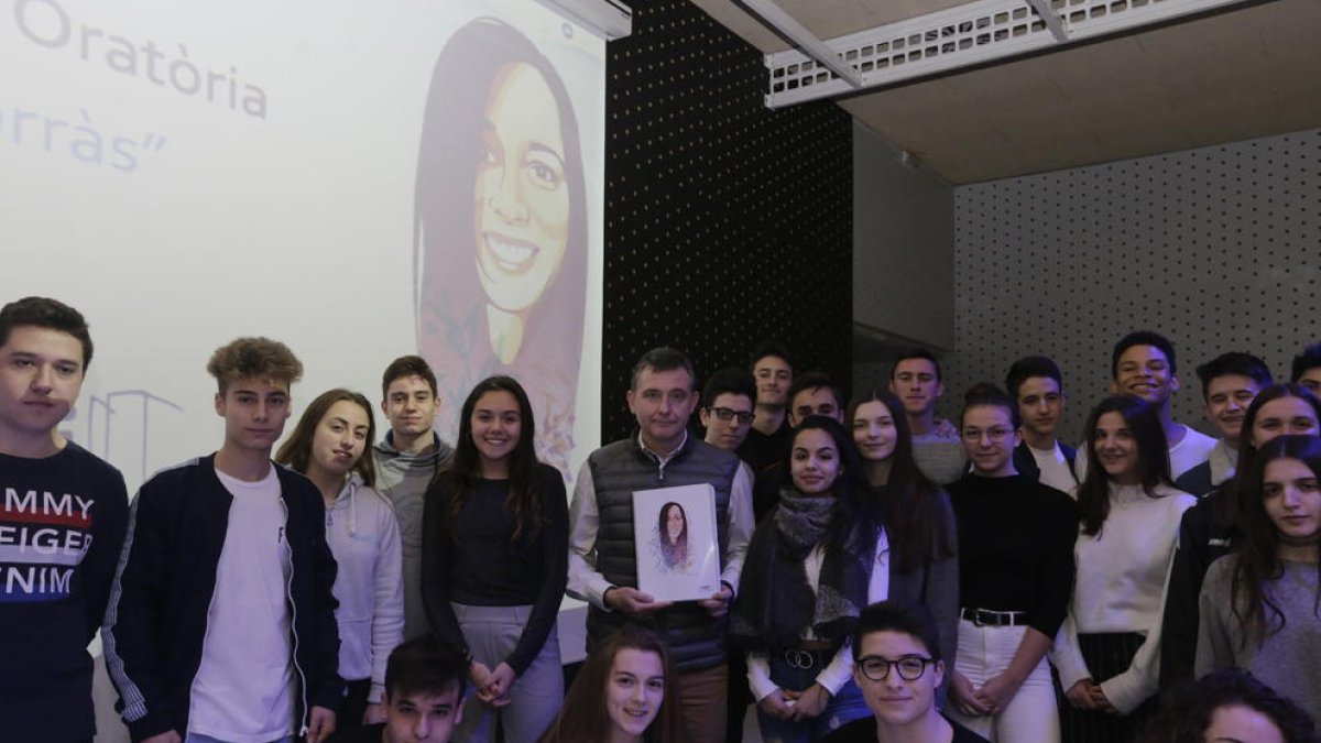Alumnes i el director del Montsuar, amb el llibre i davant d’una imatge de Núria Borràs.