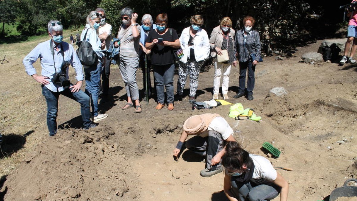 Familiars dels afusellats observen com els arqueòlegs van trobant restes a la fossa.