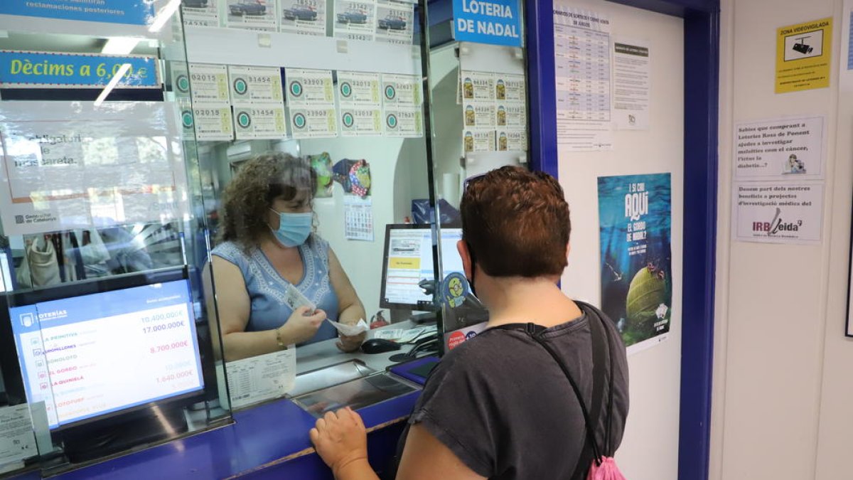 Una clienta comprant loteria a la Rosa de Ponent de Lleida.