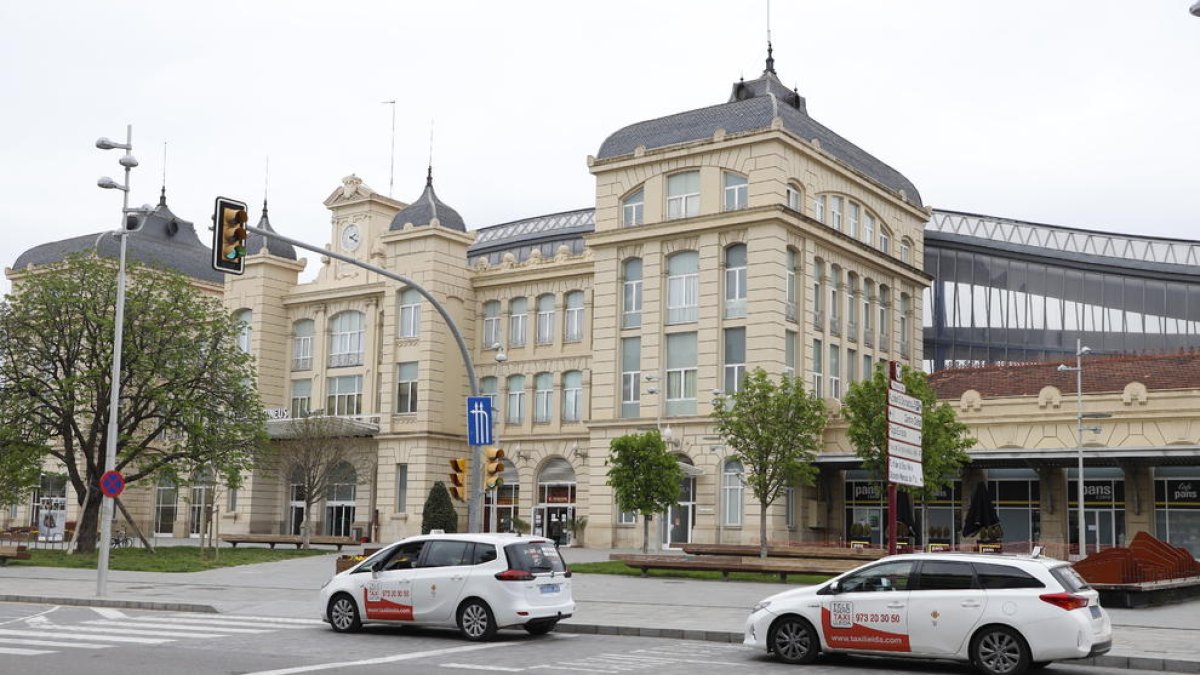 Dos taxis esperan clientes en la parada habilitada frente a la estación de trenes de Lleida.