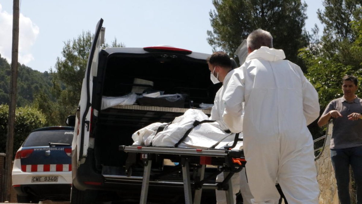 Els serveis funeraris s’emporten el cos de la dona assassinada.