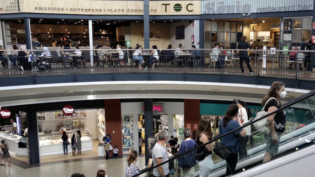 Desenes de persones es concentren en un centre comercial de Girona en el primer dia obert.