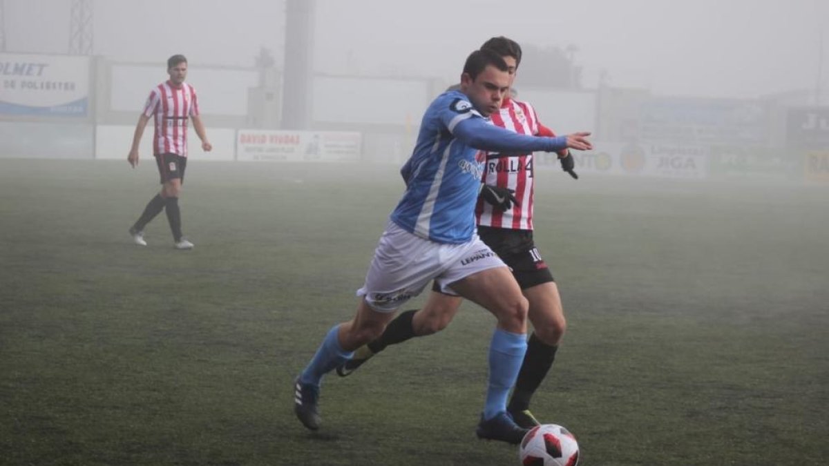 Un jugador del Binéfar disputa el balón con un rival durante el partido.