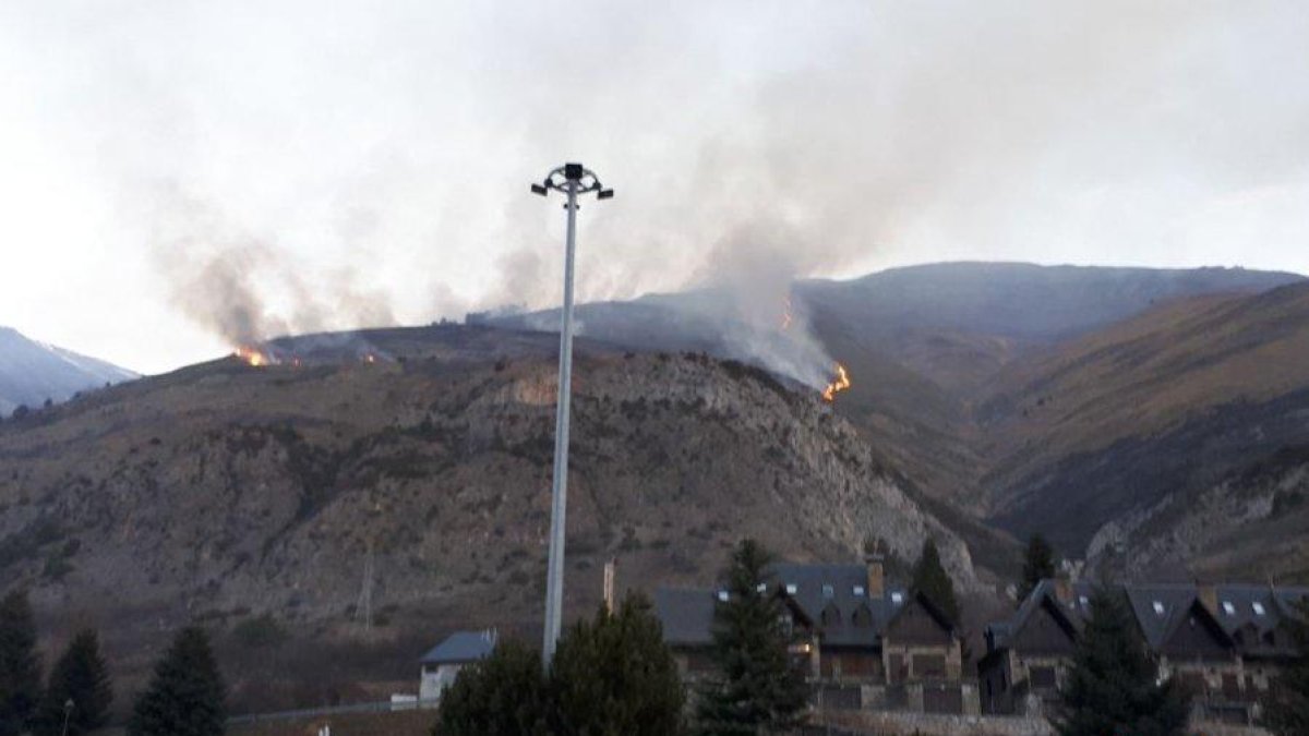 Los bomberos trabajan en un incendio de vegetación en Arties