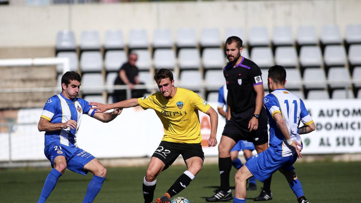 Un jugador del Lleida controla el balón, acosado por dos rivales, durante el partido de ayer.