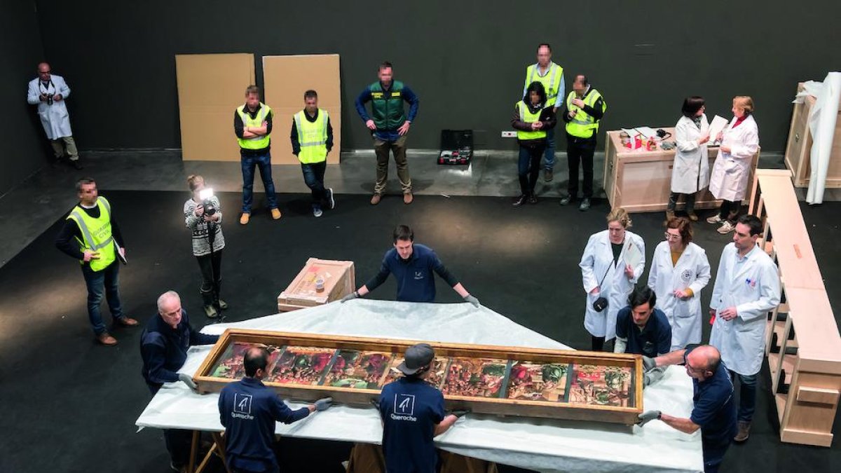 Embalaje de una de las 44 obras en el Museu de Lleida, bajo la mirada de técnicos y efectivos policiales.