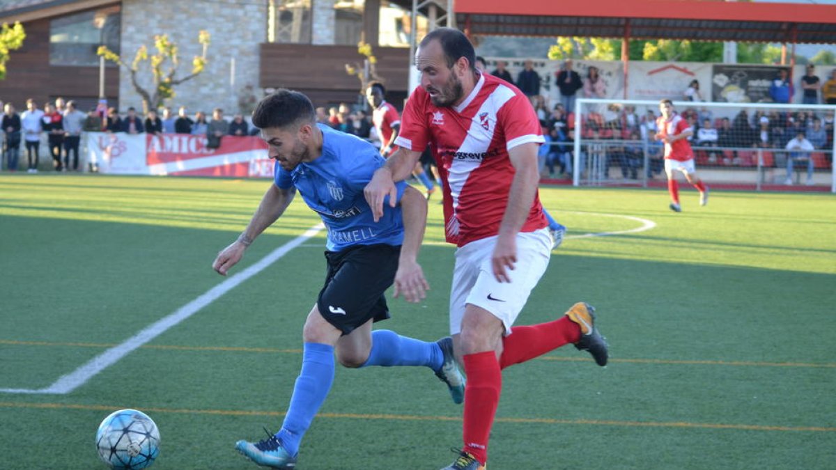 Un jugador del Alcarràs conduce el balón ante la presión de un rival.