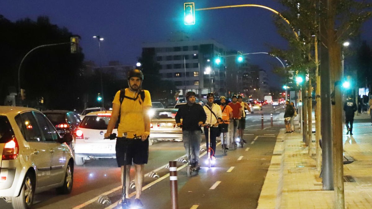 Usuaris de patinets elèctrics circulen pel carril bici de l’avinguda Catalunya.