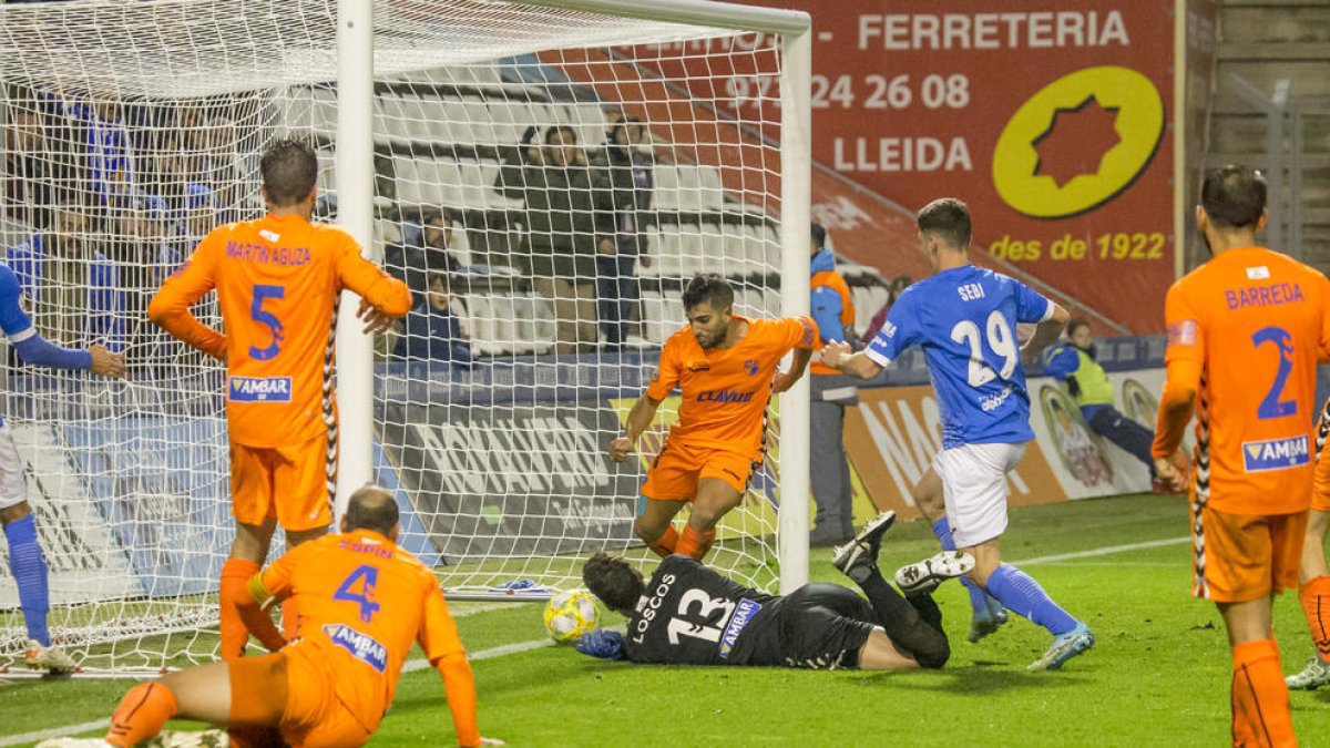 Joan Oriol centra el balón presionado por Carlos Barreda.