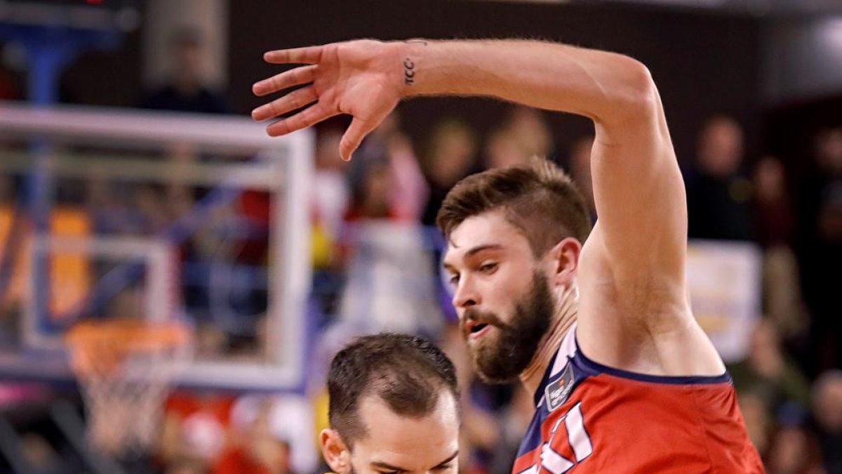 Pau Rivas porta la pilota davant de la pressió de William Magarity.