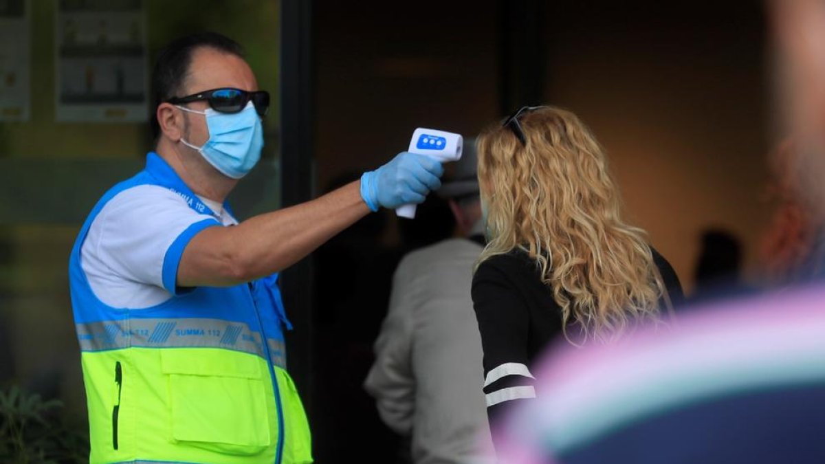 Toma de temperatura a una paciente que acude a realizarse un test en un centro de salud de Madrid.