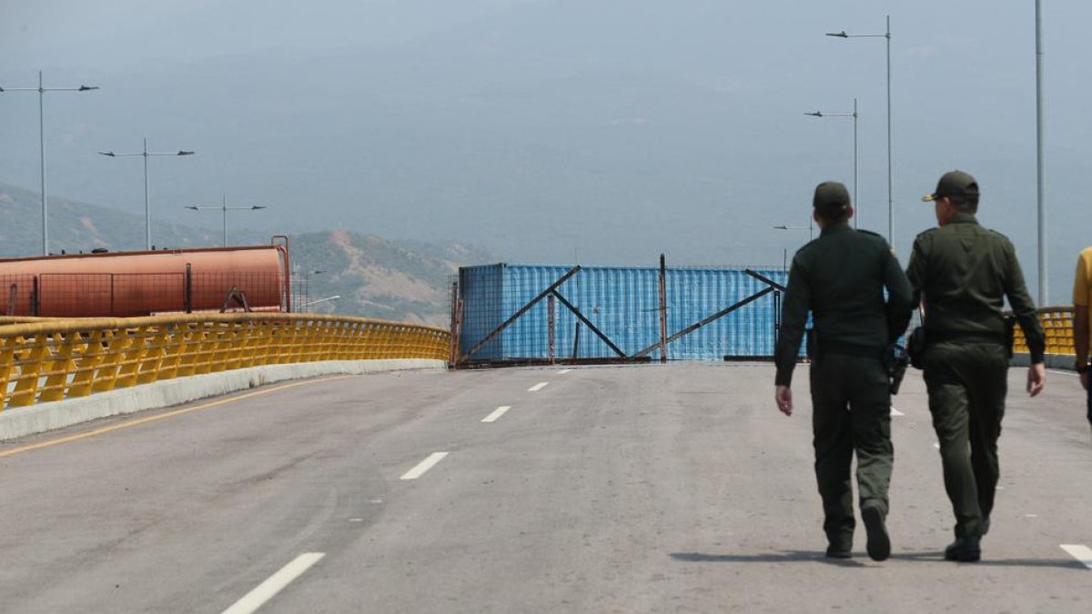 Militars vigilen el pont amb grans remolcs com a barricada.