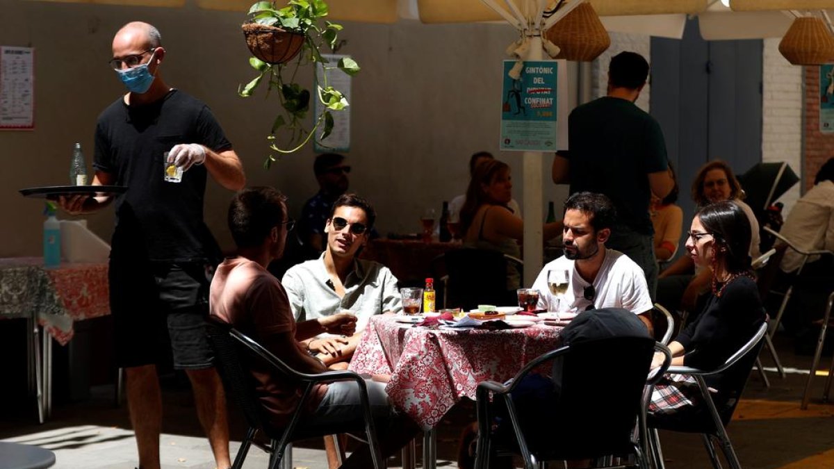 Varios jóvenes disfrutan de un vermut en una terraza del Poble Sec en Barcelona.