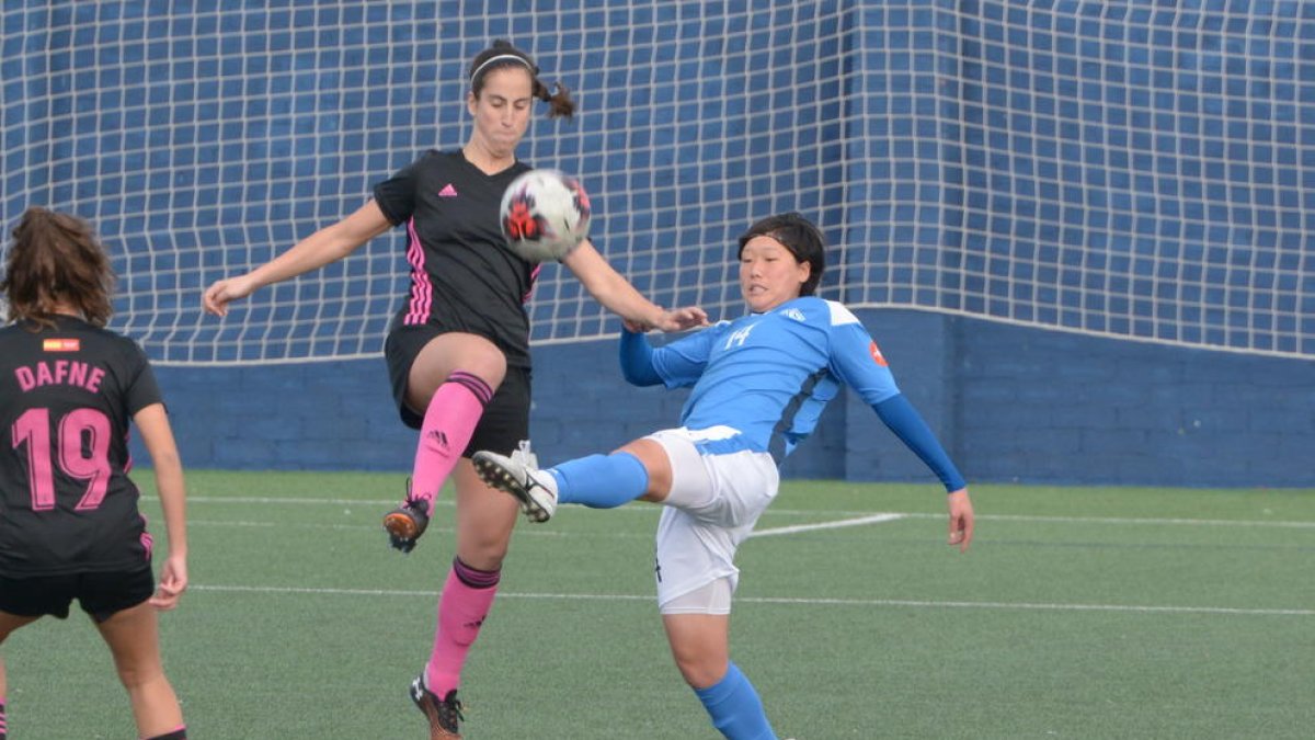 La jugadora de l’AEM Hisui intenta controlar una pilota davant d’una rival.