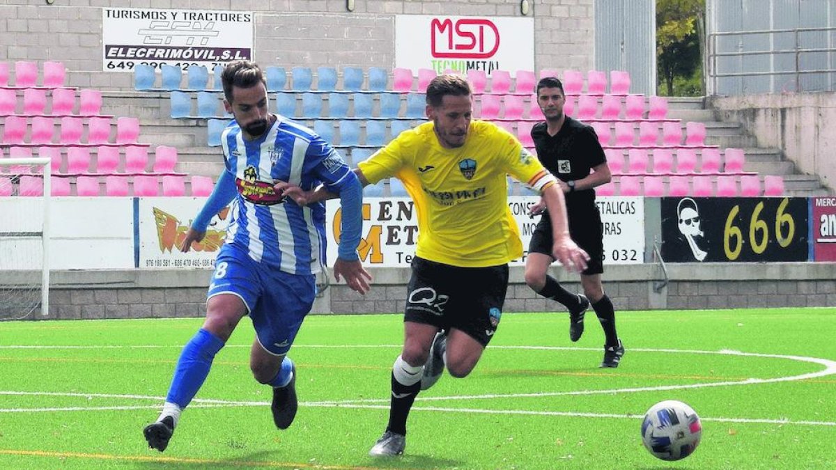 Marc Martinez intenta hacerse con  el balón pese a la oposiciòn de un defensor del Ejea.
