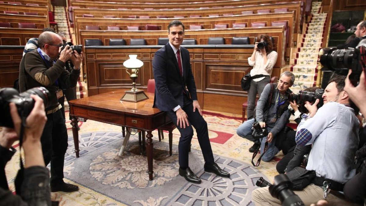 Pedro Sánchez posa sonriente en el hemiciclo del Congreso tras obtener una votación favorable a su investidura.