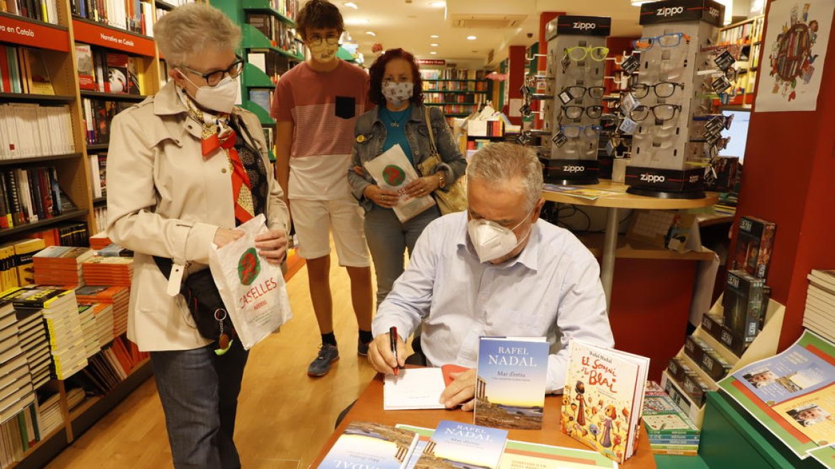 El escritor Rafel Nadal, ayer en la librería Caselles de Lleida firmando ejemplares a sus lectores.