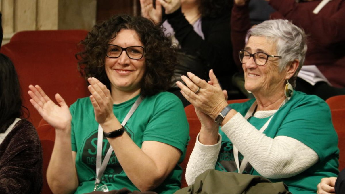 Dos miembros de la PAH aplauden la votación del Parlament.