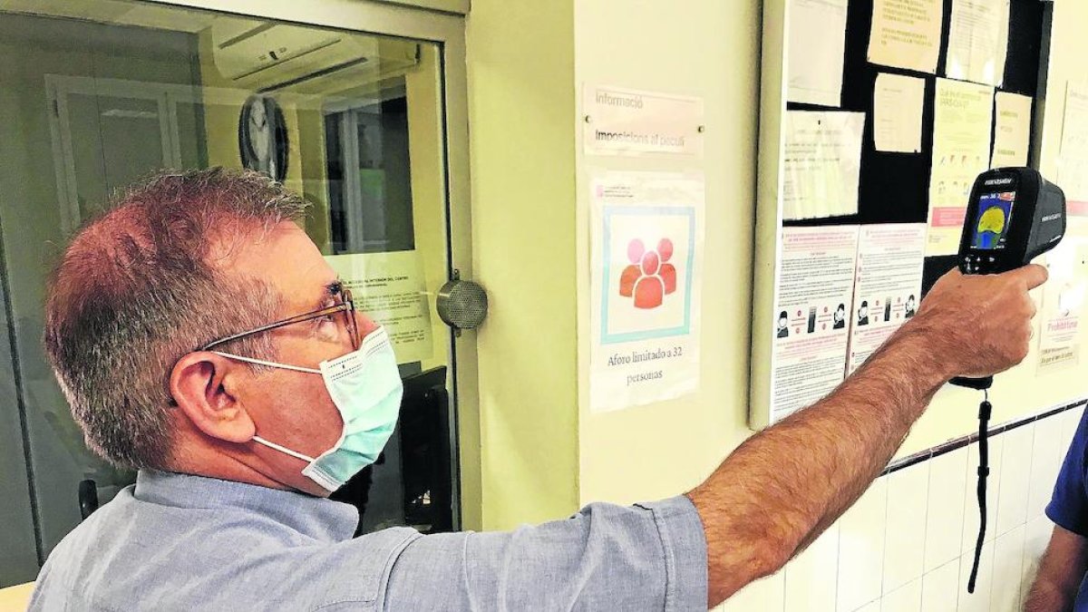 Un funcionari de Ponent prenent la temperatura.