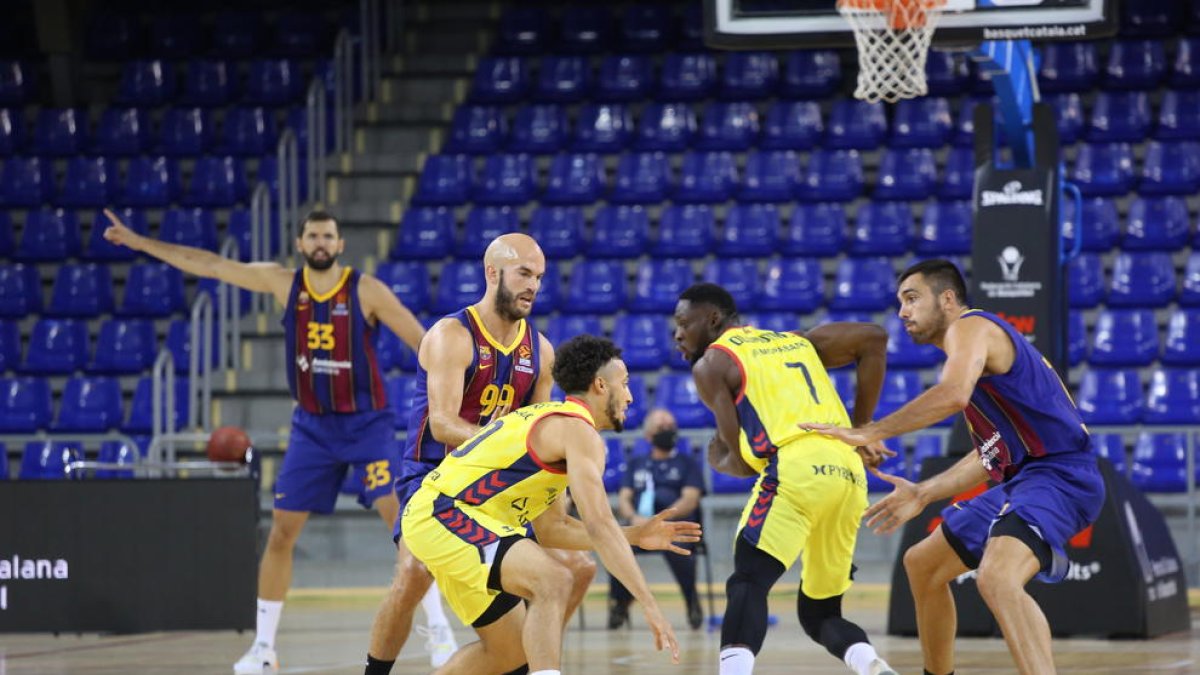 Nick Calathes y Pierre Oriola defienden a Jeremy Senglin.