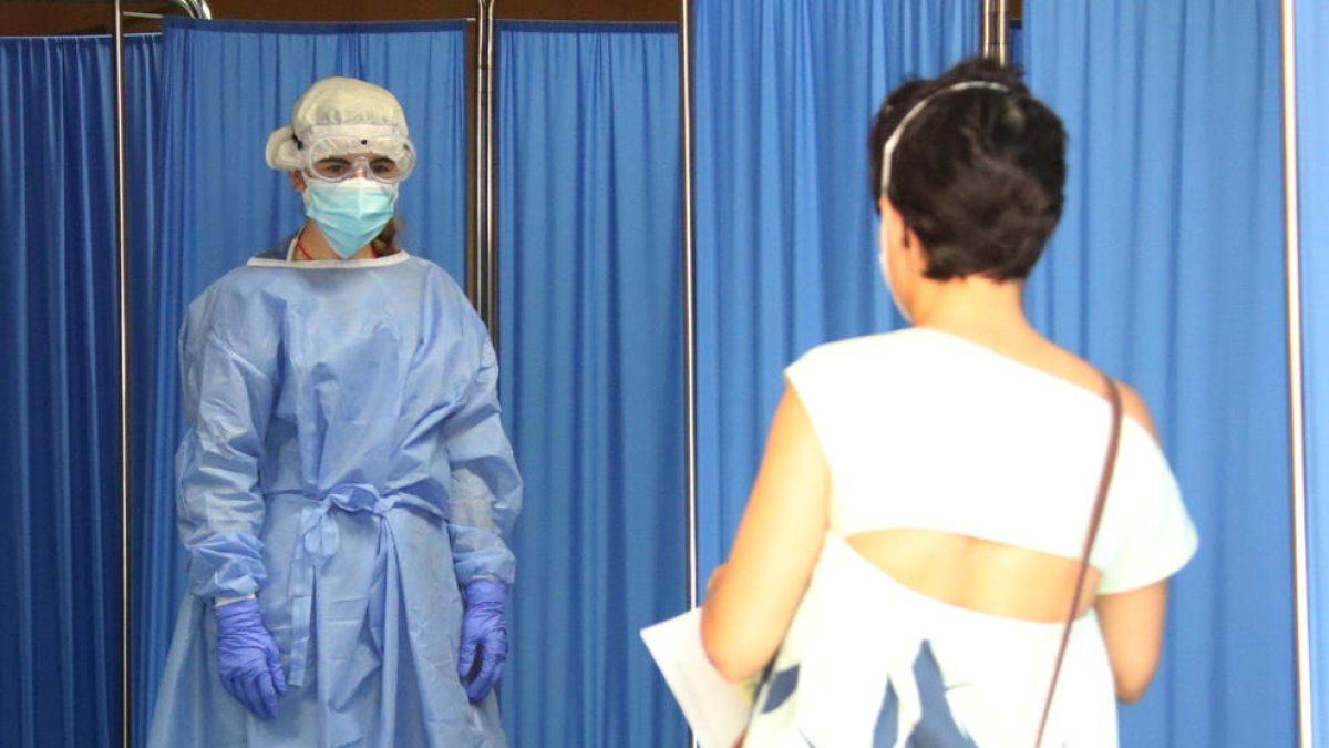 Una sanitaria recibe a una paciente que va a someterse a un test PCR, ayer, en Vilafranca del Penedès.
