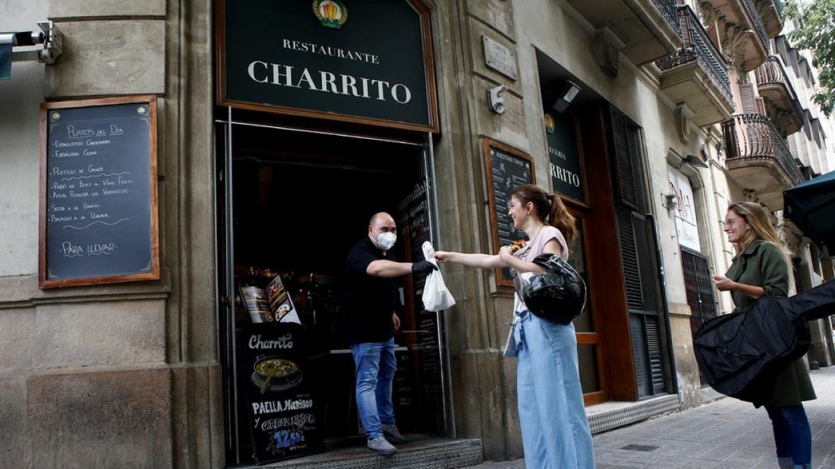 Unes clientes recullen menjar per emportar-se en un establiment de Barcelona.