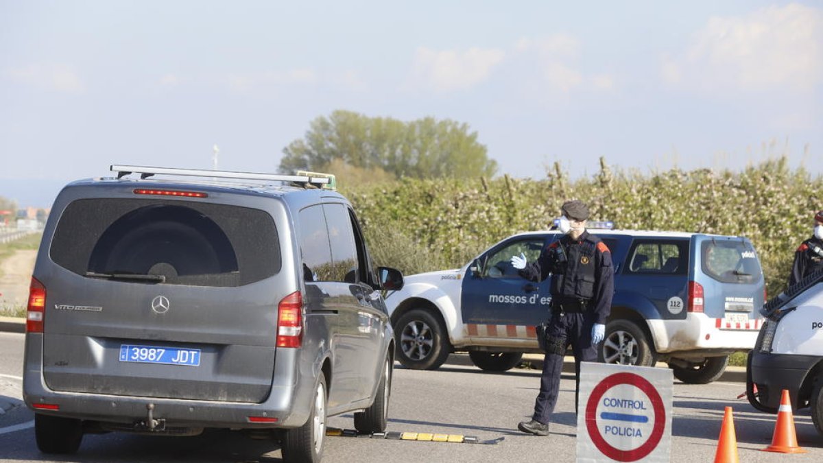 Un mosso, con mascarilla y guantes, en el control del pasado viernes en la N-240 en Juneda.