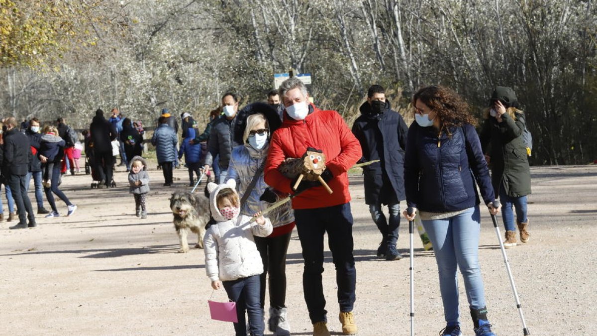 Una família després de recollir el tió ahir al matí al parc de la Mitjana de Lleida.