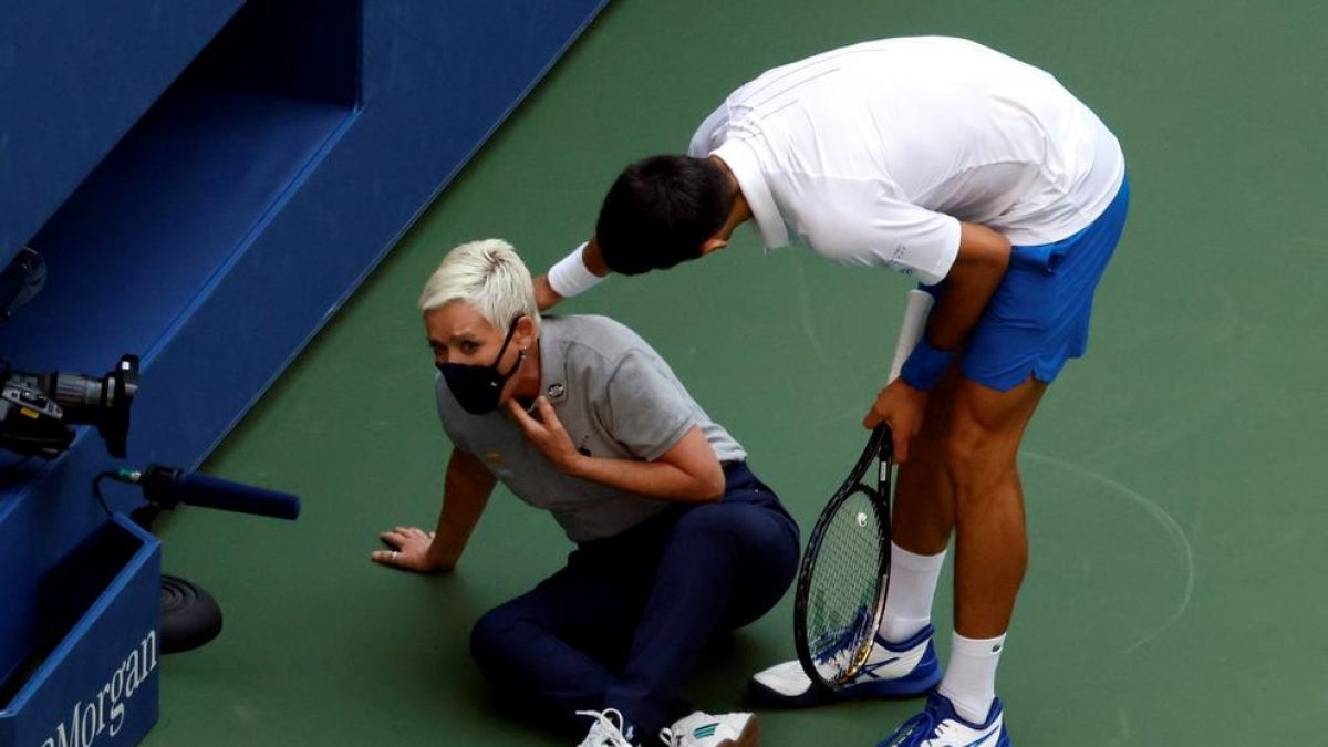 Novak Djokovic s’interessa per l’estat de la jutge de cadira després de rebre el cop de pilota.