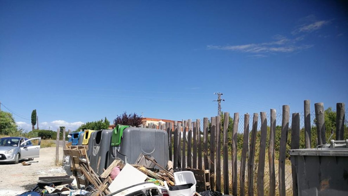 Imagen de vertidos en el Camí de la Mariola, donde se puede ver parte de la carrocería de un coche.
