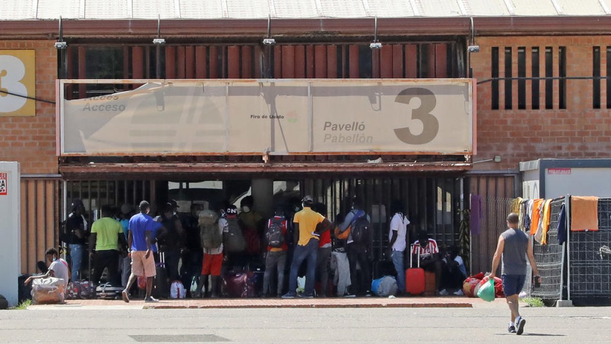 Varios temporeros y personas sin hogar esperan para poder entrar en el pabellón 3 la semana pasada.