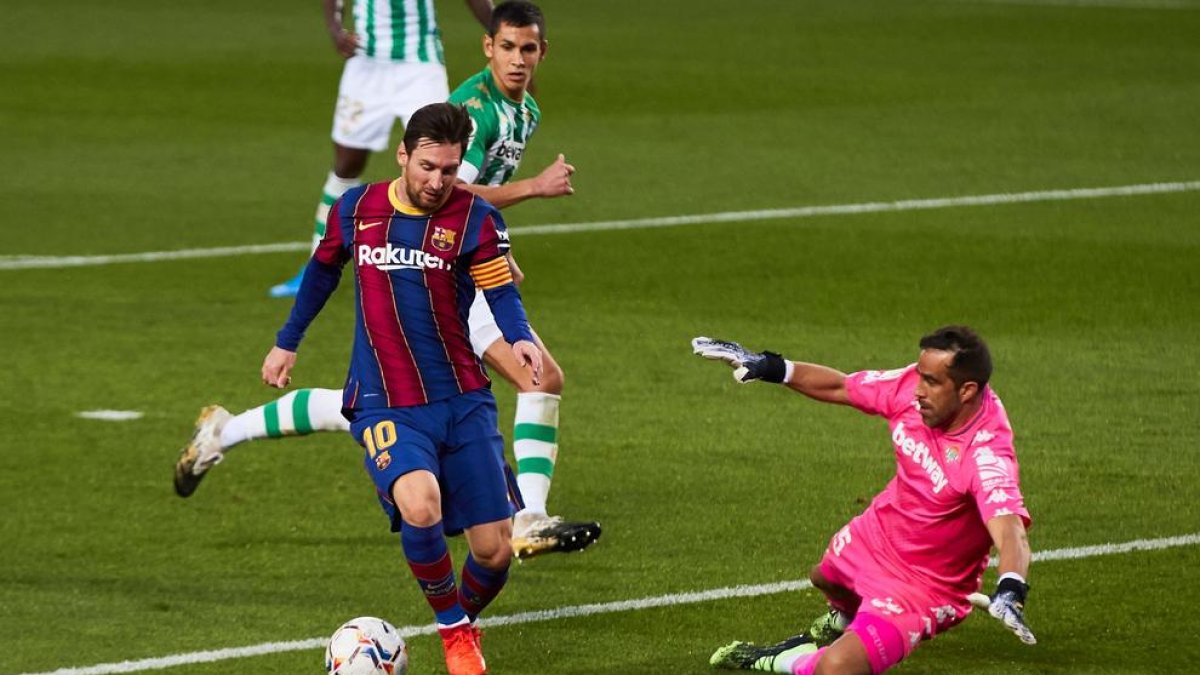 Leo Messi intenta superar a su excompañero Claudio Bravo, portero del Betis.