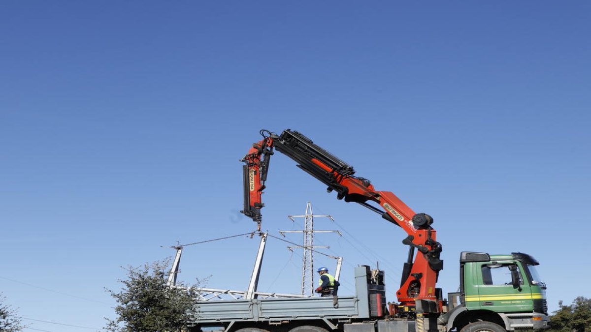 Operarios desmontando la línea centenaria en el Port de Comiols.
