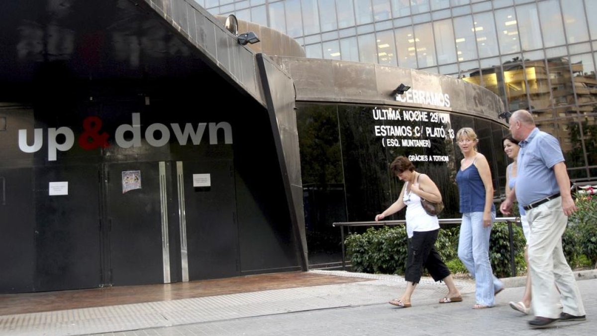 Diversos transeünts passen per davant del club Up&Down de Barcelona.