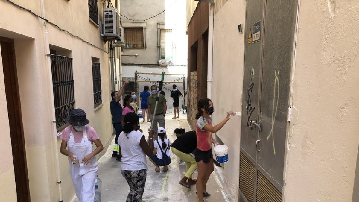 Imatge dels treballs que es duen a terme per pintar façanes al carrer Vilaclosa.
