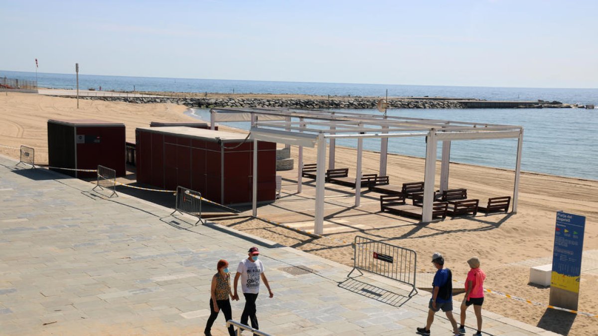 Algunas personas paseando ayer por el paseo marítimo de la playa del Bogatell en Barcelona.
