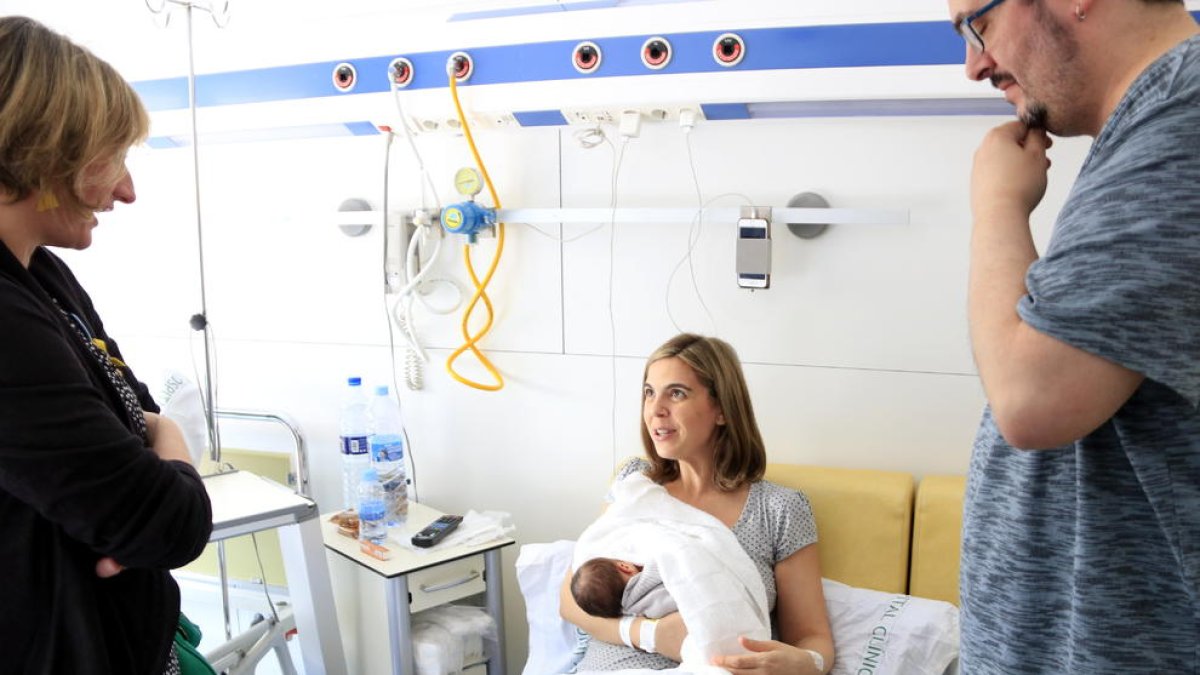 Anna y Alberto, con su hijo, Roc, conversando con la consellera de Salud, Alba Vergés, en la Maternidad del Hospital Clínic, este viernes.