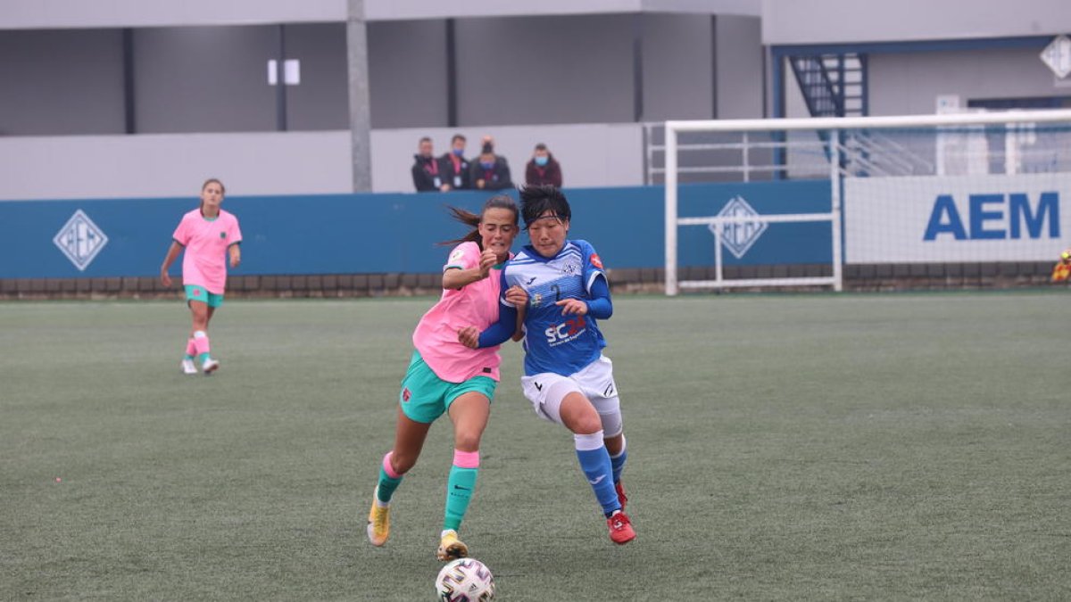 Una jugadora local intenta tallar l’avanç d’una rival.