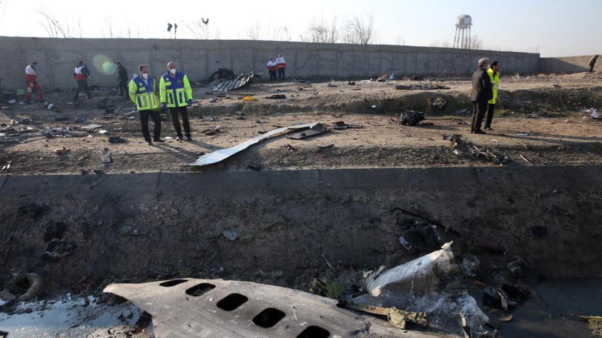 Membres dels serveis d’emergència observen part del fuselatge del Boeing 737 sinistrat.