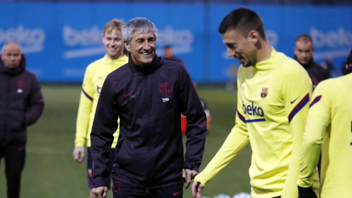 Quique Setién sonríe ante Lenglet ayer durante el entrenamiento del equipo barcelonista.