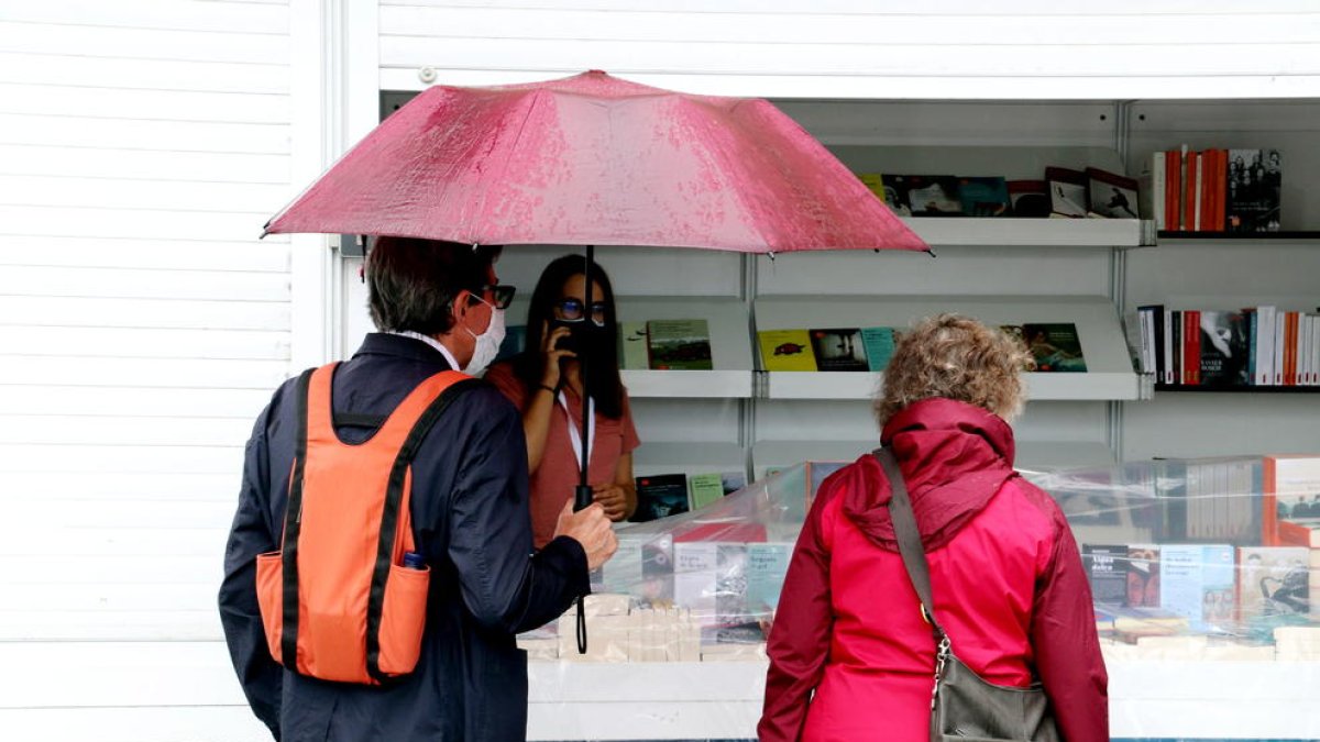 Visitantes bajo la lluvia en la Setmana del Llibre en Barcelona.