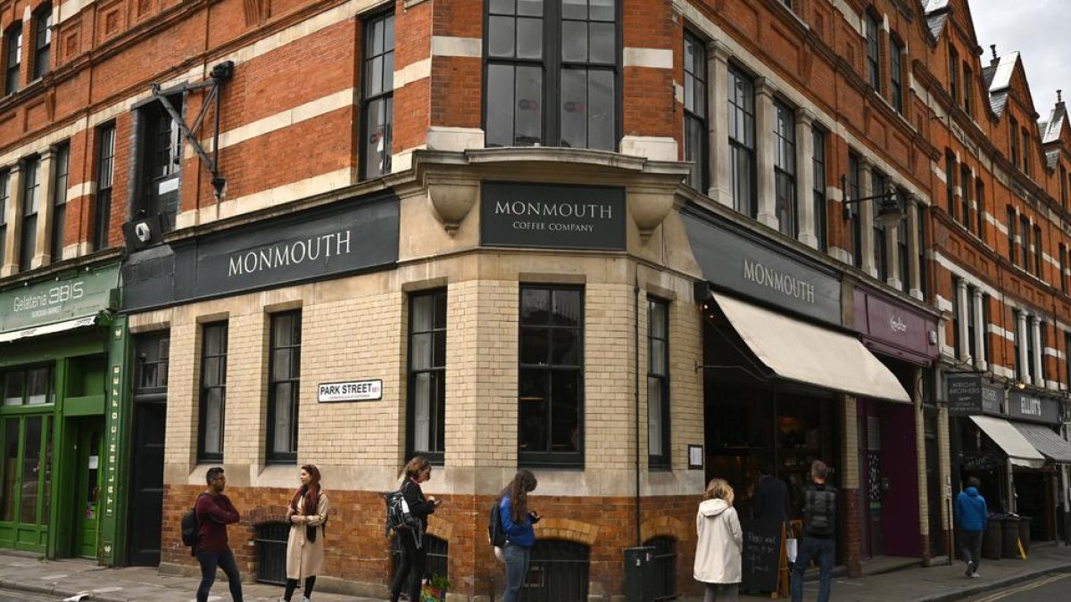 Ingleses haciendo cola para entrar en una tienda, ayer en Londres.