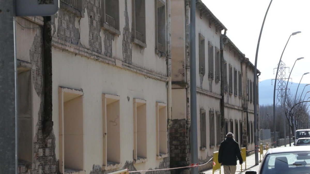 Un hombre junto a las antiguas casas de los ferroviarios, valladas por riesgo de desprendimientos.