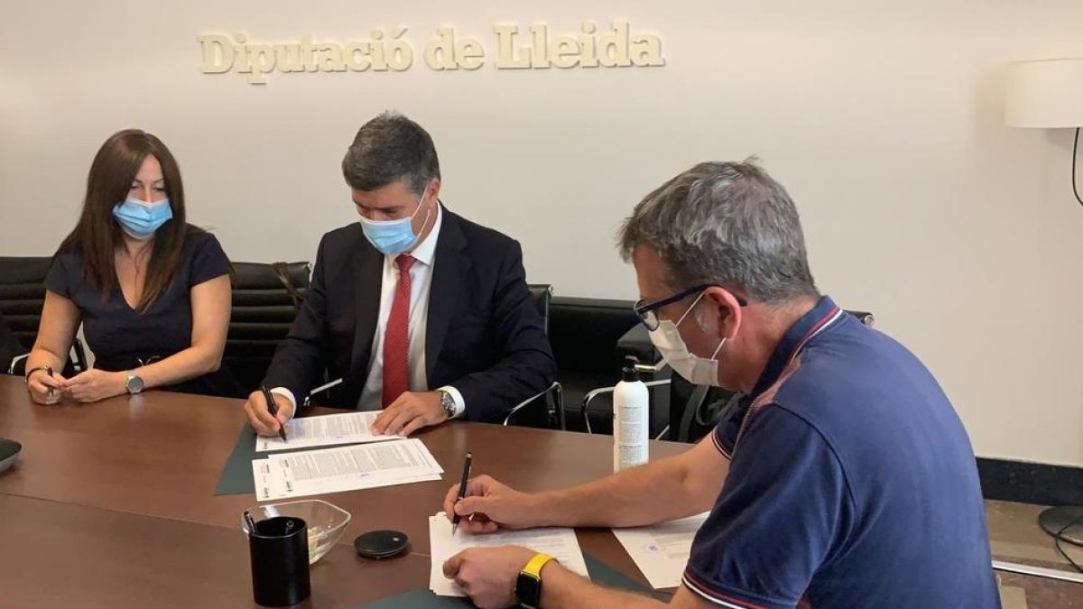 El presidente de la Diputación, Joan Talarn (derecha) firmando ayer el crédito de 10 millones.